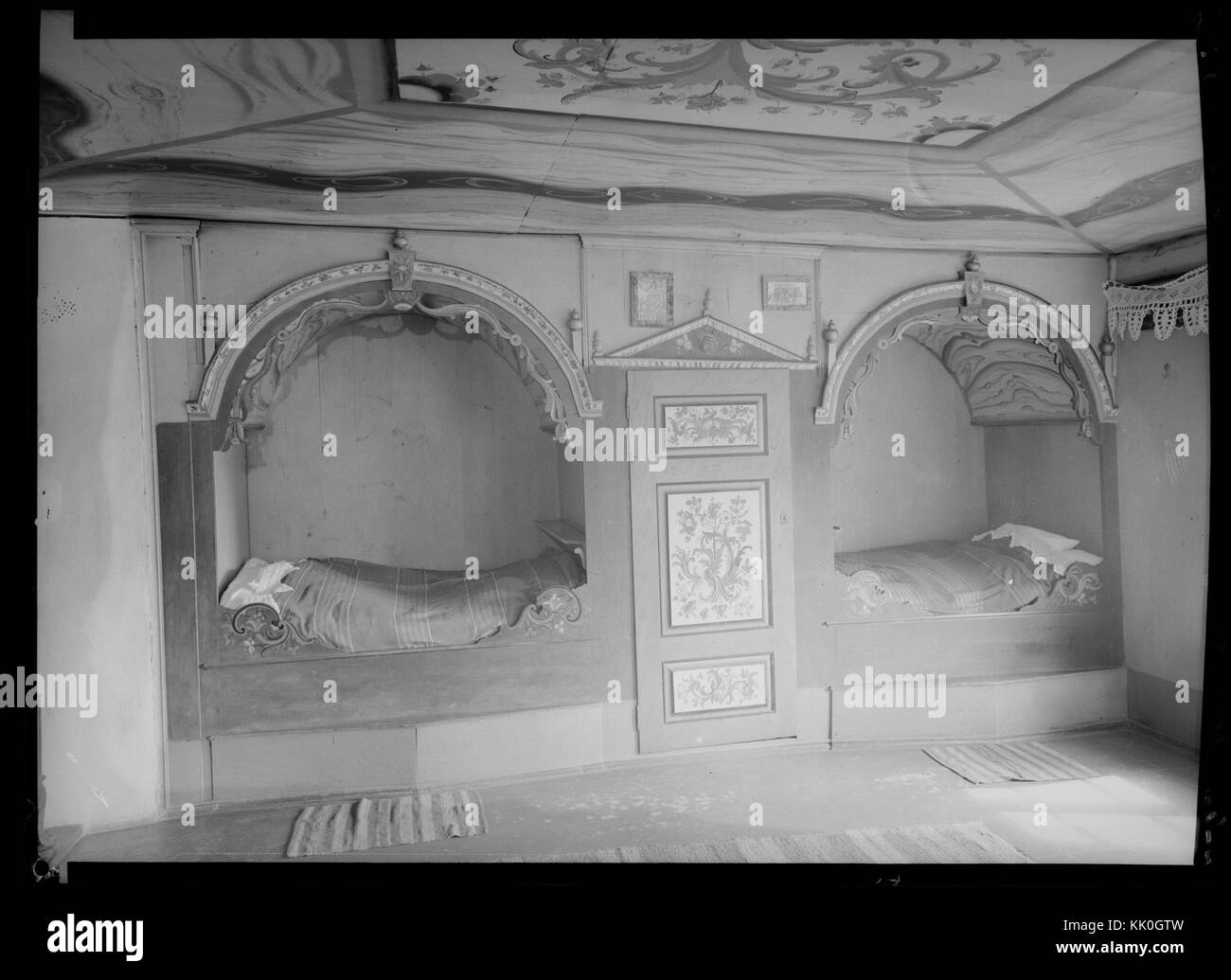 This photograph, taken in Morgedal, Norway, shows a traditional interior with rosemaling (decorative painting) and a himmelseng (heavenly bed), which are characteristic of Norwegian heritage. The image highlights the region's cultural craftsmanship. Stock Photo