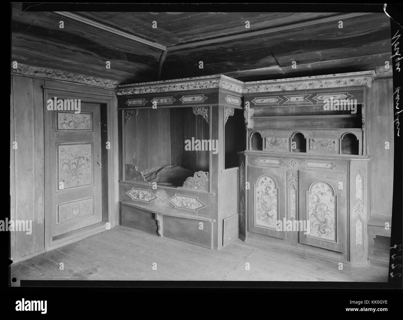 This photograph showcases traditional Norwegian interior design, including a painted *himmelseng* (canopy bed) and *rosemaling* (decorative painting), reflecting the country's folk art traditions. Stock Photo