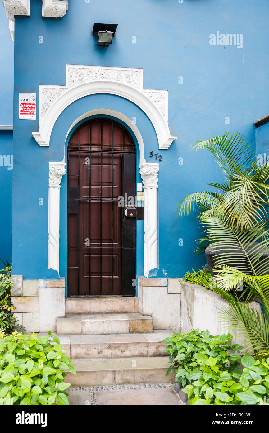 House door, steps and white decorative stucco work in a blue wall of a typical colonial style house in an affluent Miraflores suburb, Lima, Peru Stock Photo