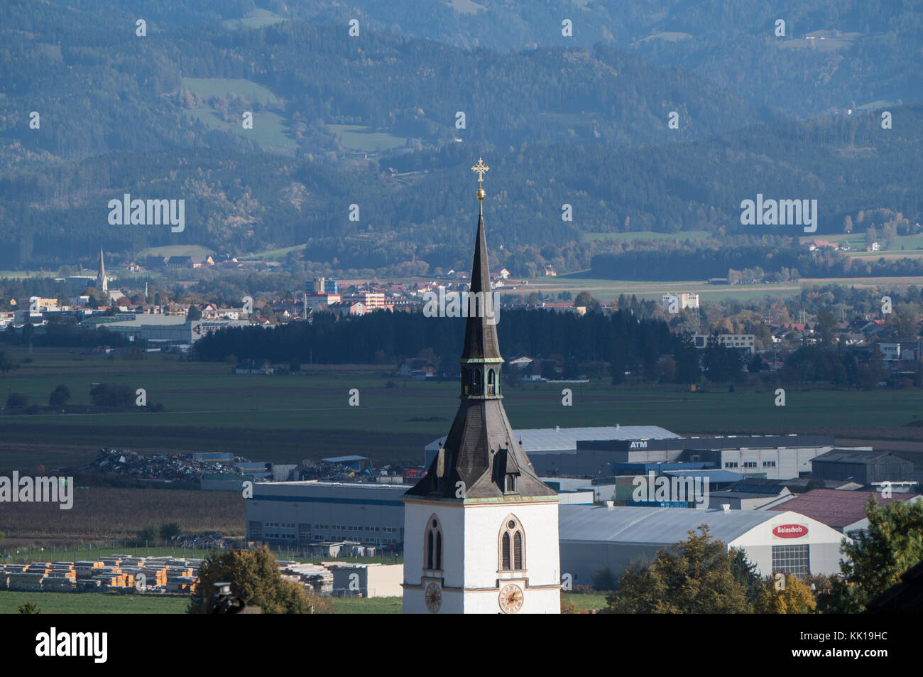 Fohnsdorf, Austria - 12.10.2017: The village Church spire in the foreground with the Mur river valley in the background Stock Photo