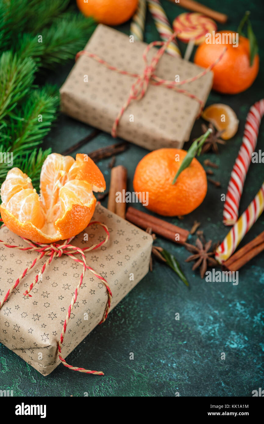 Fresh mandarins with leaves, candy canes, gift boxes in kraft paper and ...