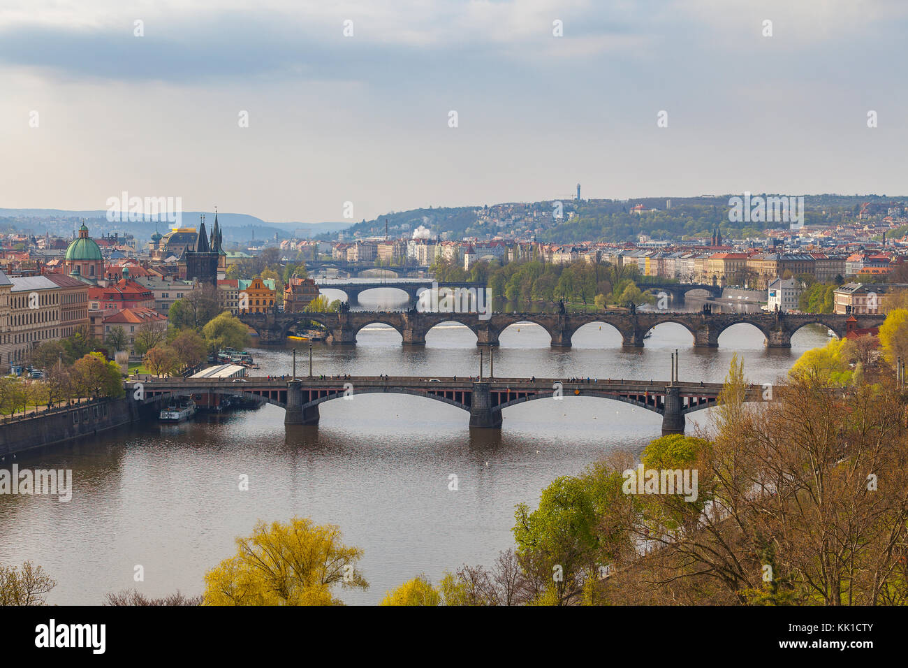 Remarkable view of Prague bridges over Vltava river with historic embankment. Daytime, spring season, green park at the foreground Stock Photo