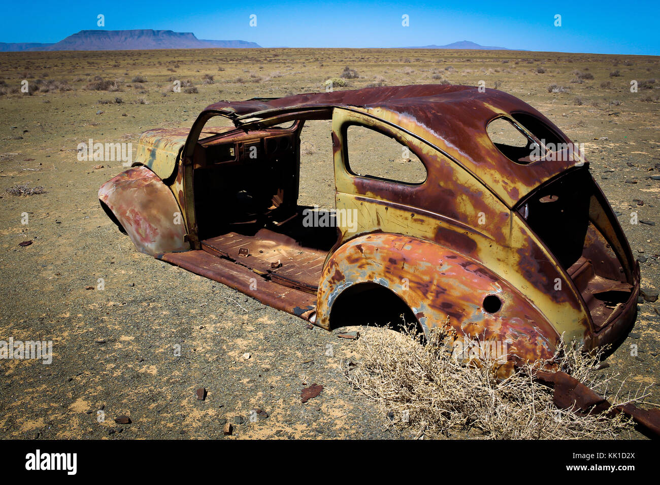 Old broken rusted car in desert Stock Photo