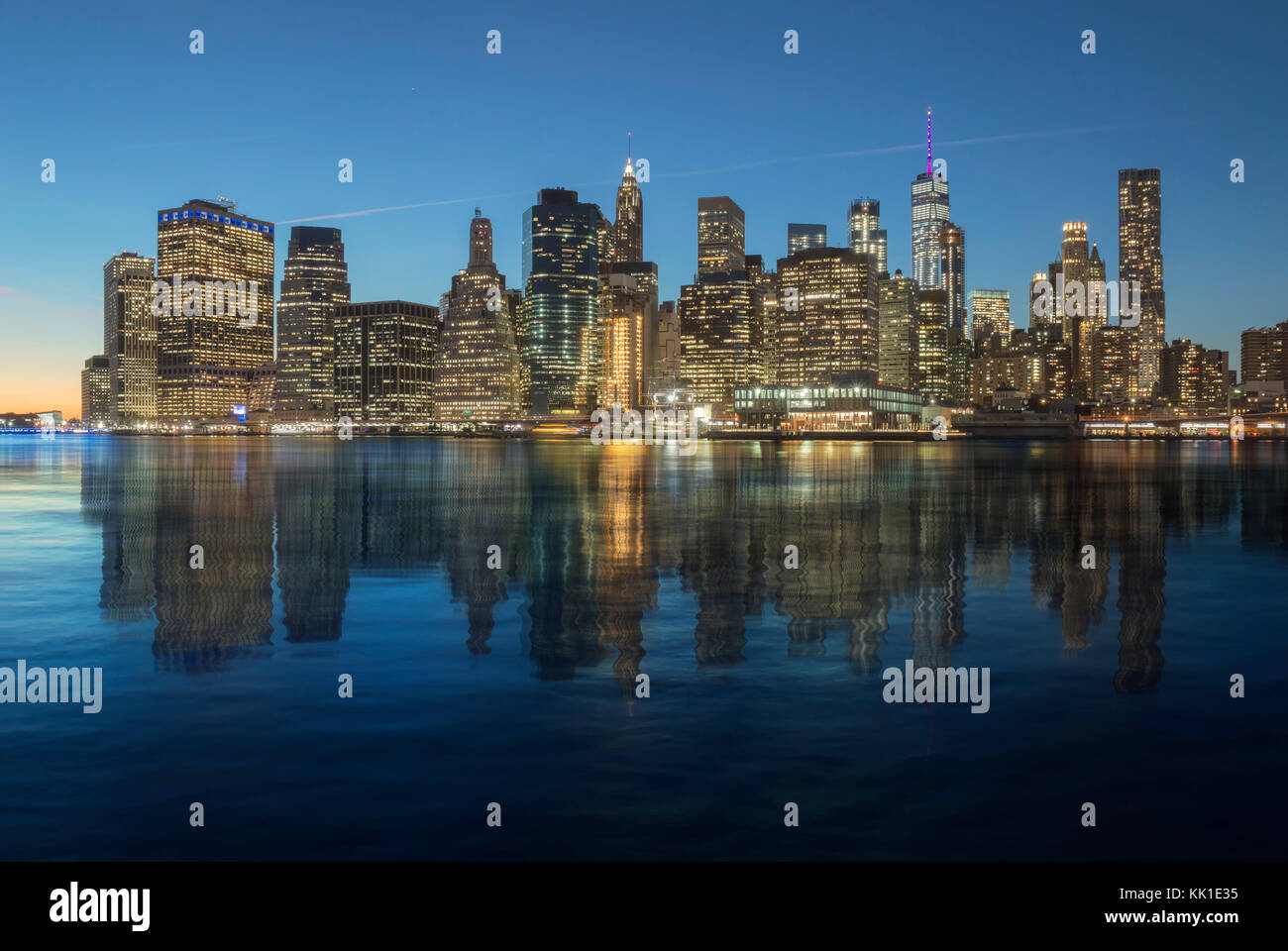 Manhattan skyline reflected in the water of the East River Stock Photo ...