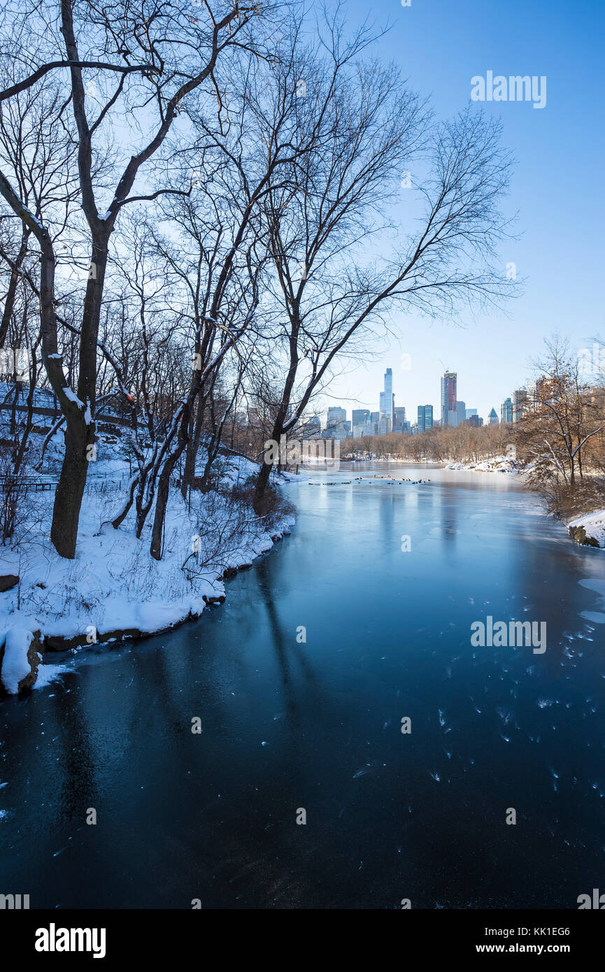 Wintry view of Central Park from the frozen lake with the urban skyline of the Upper West Side in Manhattan, New York City Stock Photo