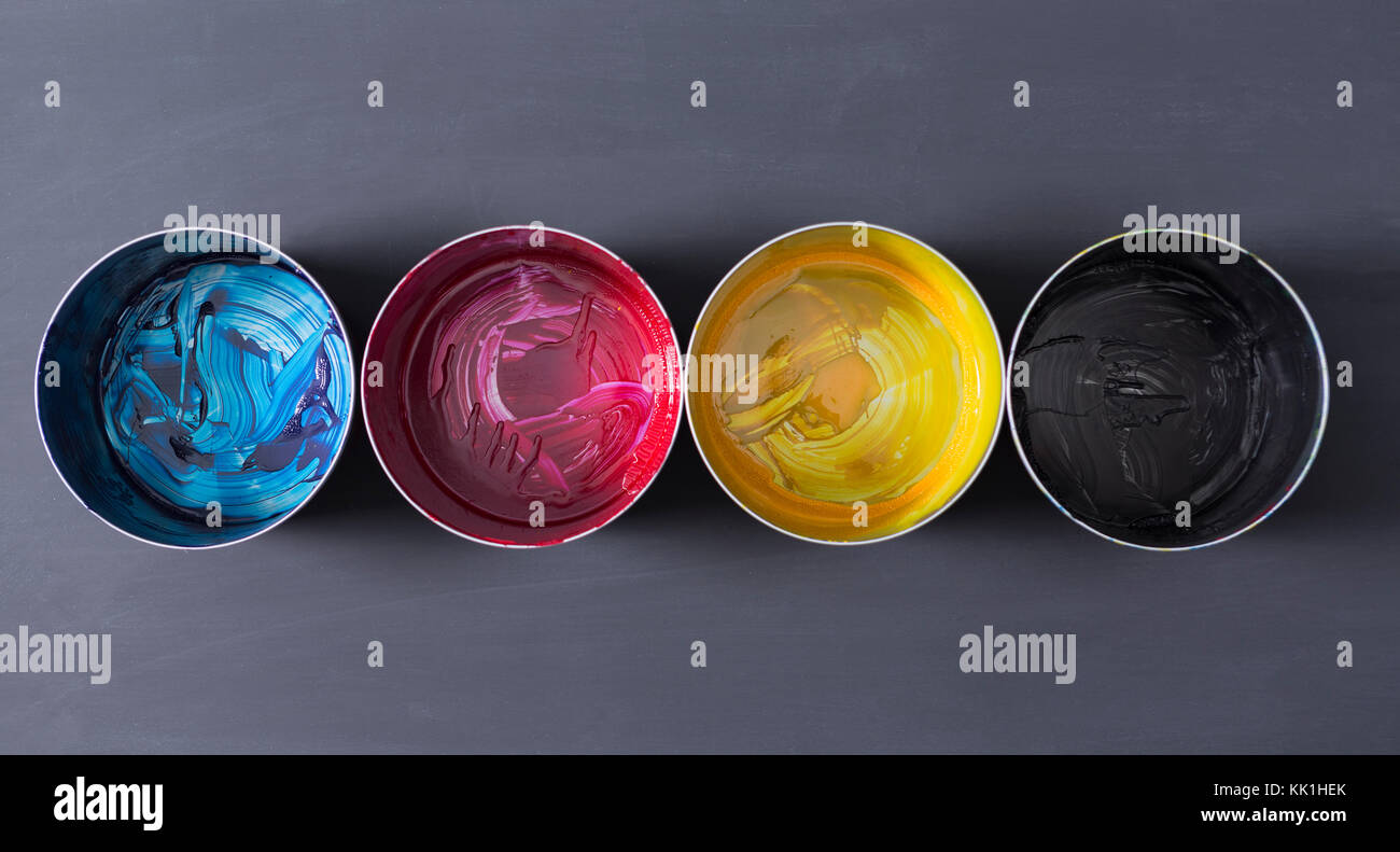 Top view of old CMYK paint cans on dark background. Colorful background ...