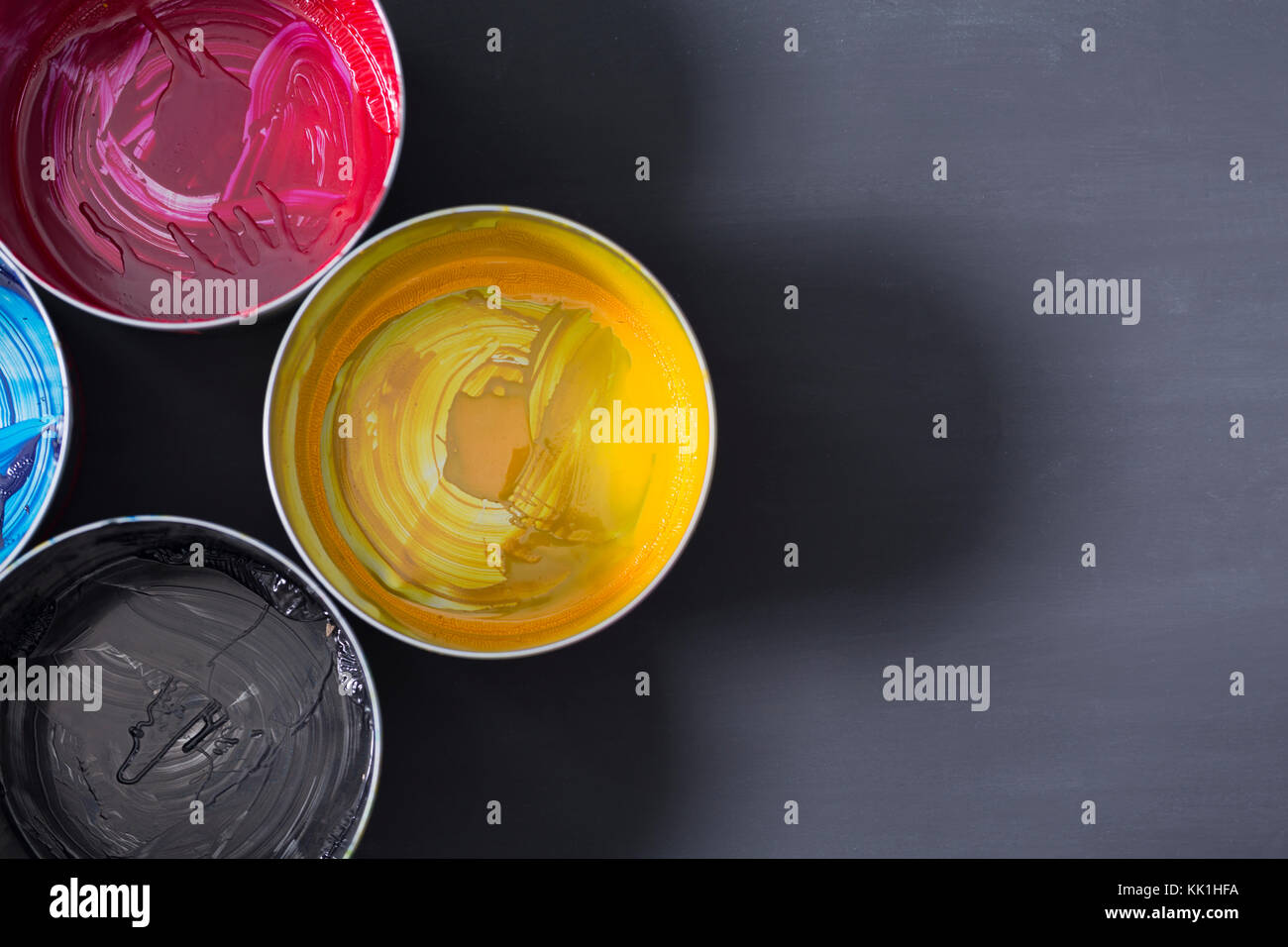 Top view of old CMYK paint cans on dark background. Colorful background ...
