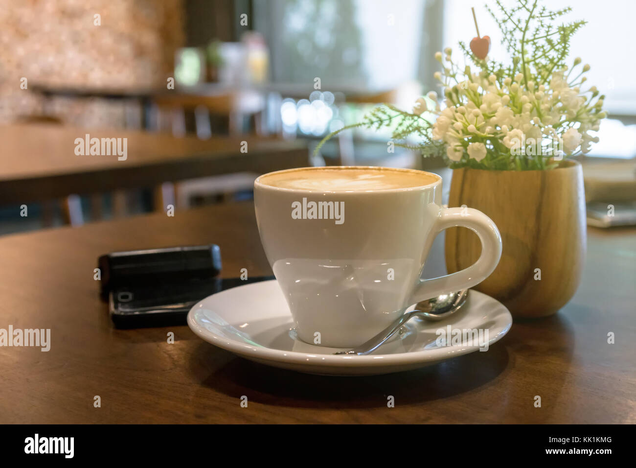 Coffee cups on the table with fake decorate fake flower and mobile