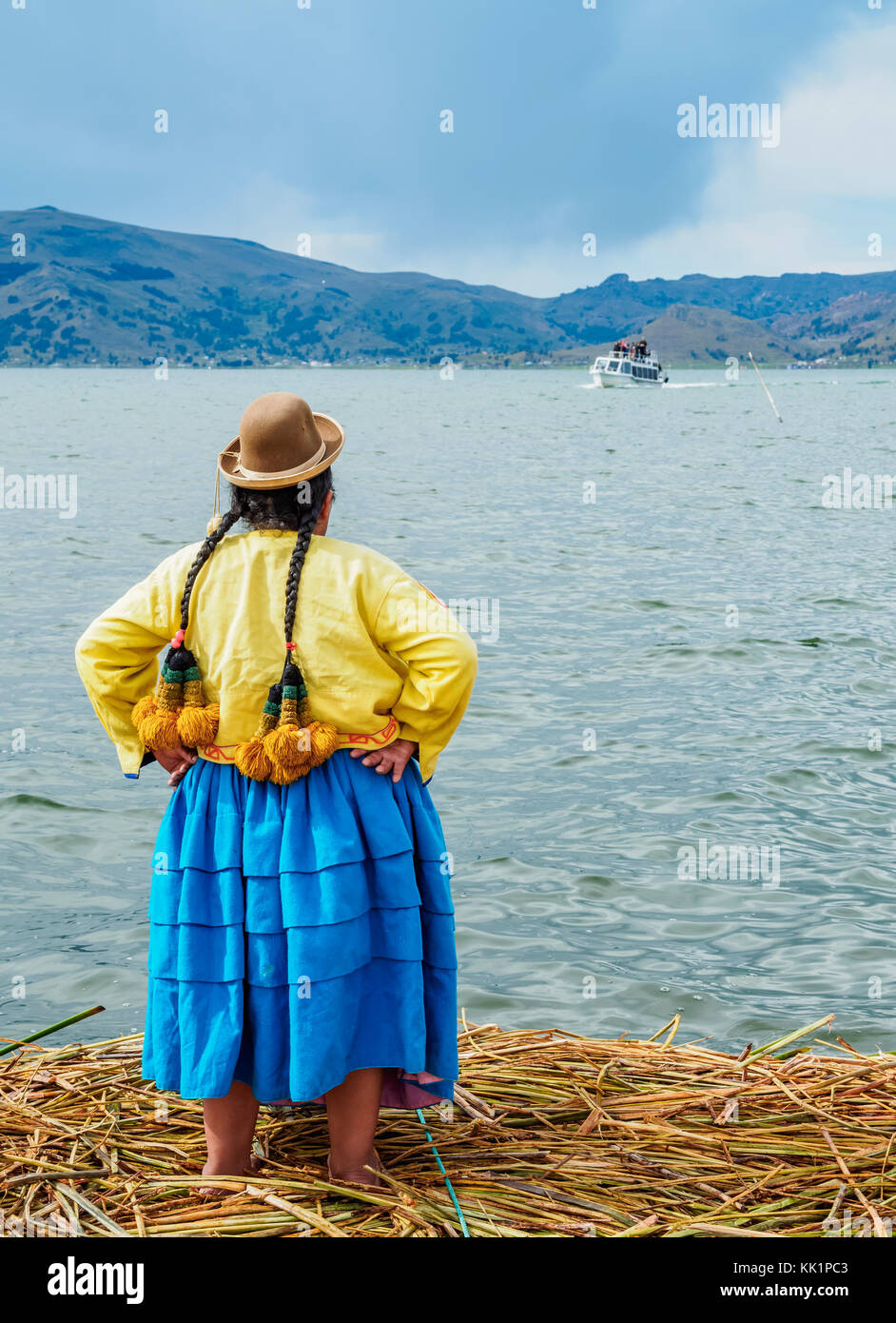 Native Uro Lady waiting for the boat with tourists, Uros Floating Islands, Lake Titicaca, Puno Region, Peru Stock Photo