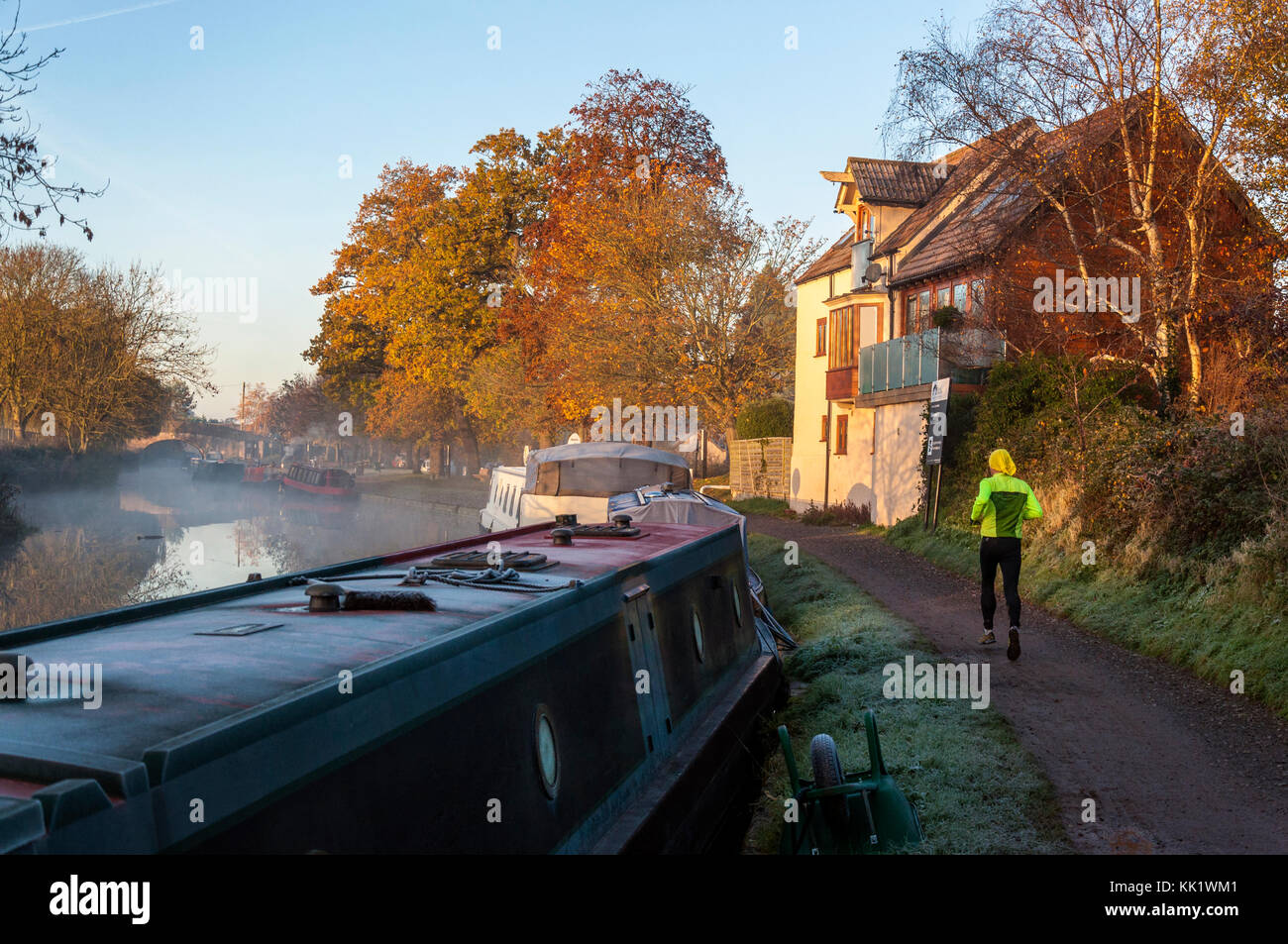 Misty early morning  jogger on Kennet and Avon Canal at Bathampton, Somerset, England, UK Stock Photo