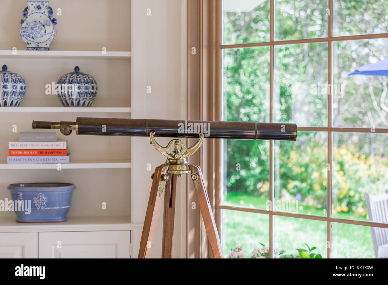 telescope on a tripod in an east hampton living room Stock Photo Alamy