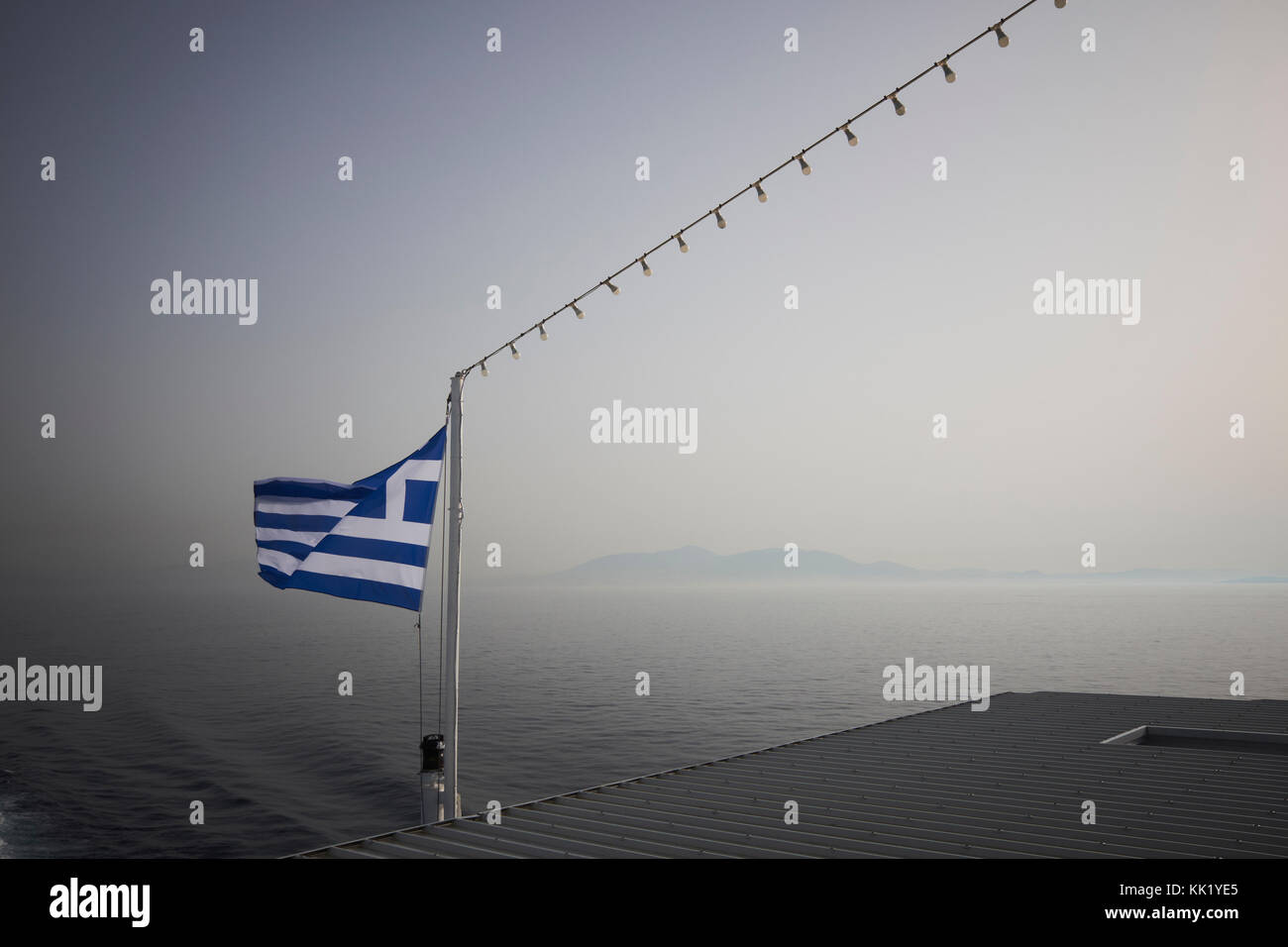 The Greek Flag flying at the stern of a ferry crossing the Aegean Sea. Stock Photo