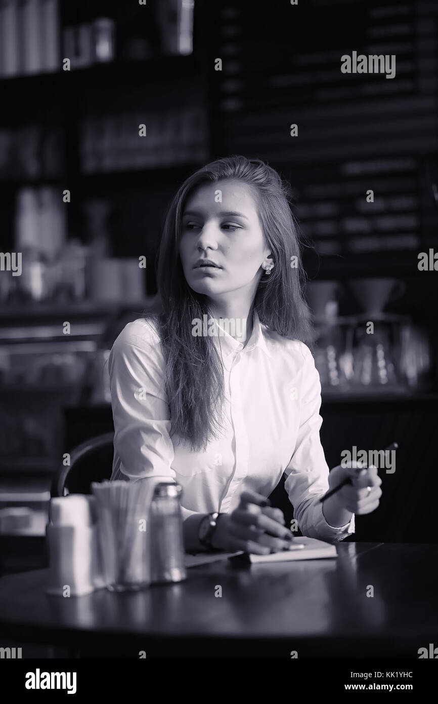 A girl in a cafe is drinking coffee. A woman is having breakfast Stock