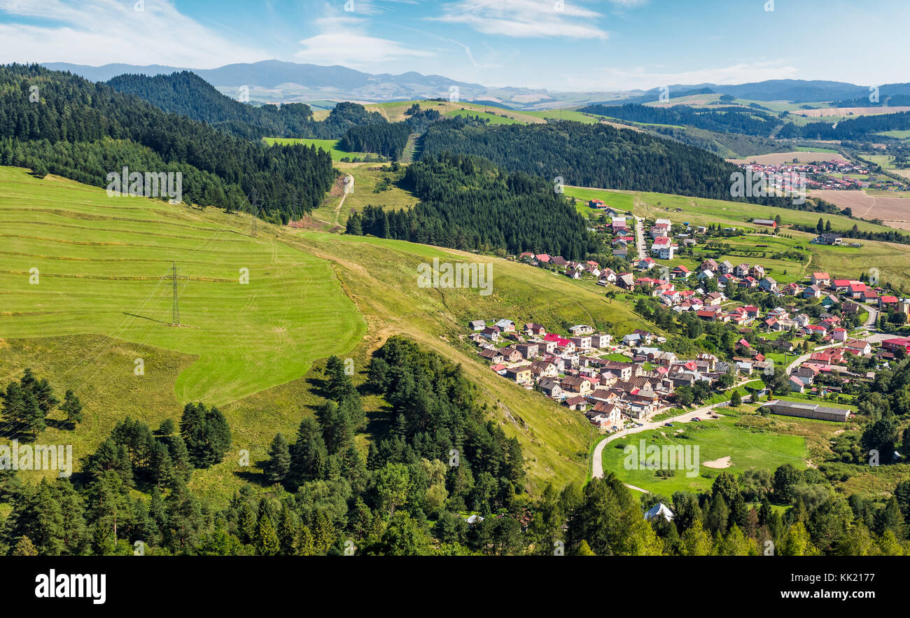 Slovakian town Stara Lubovna on grassy hillside. beautiful rural scenery in mountainous area viewed from above on a summer day. Stock Photo