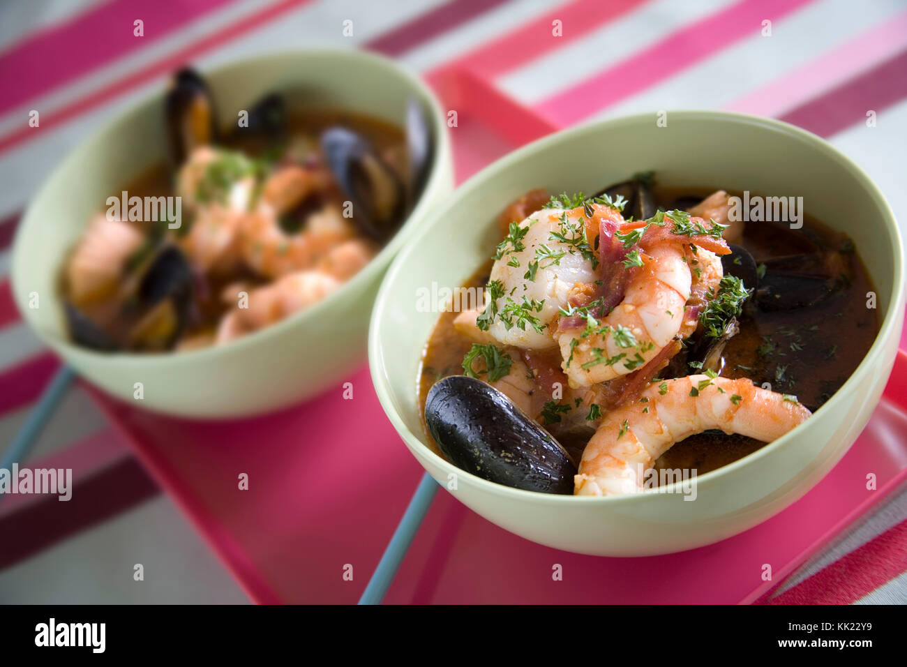 Shellfish soup with scallop, king prawns, mussels and clams garnished with chopped fresh parsley Stock Photo