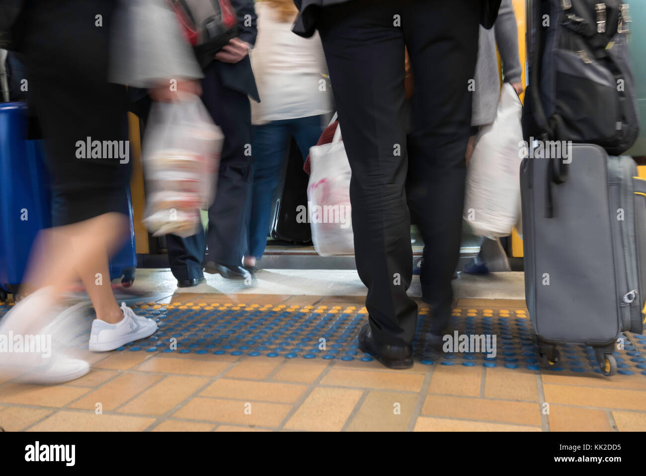 A low angle, slightly blurred shot of people or commuters boarding a train in peak hour in Sydney, Australia Stock Photo