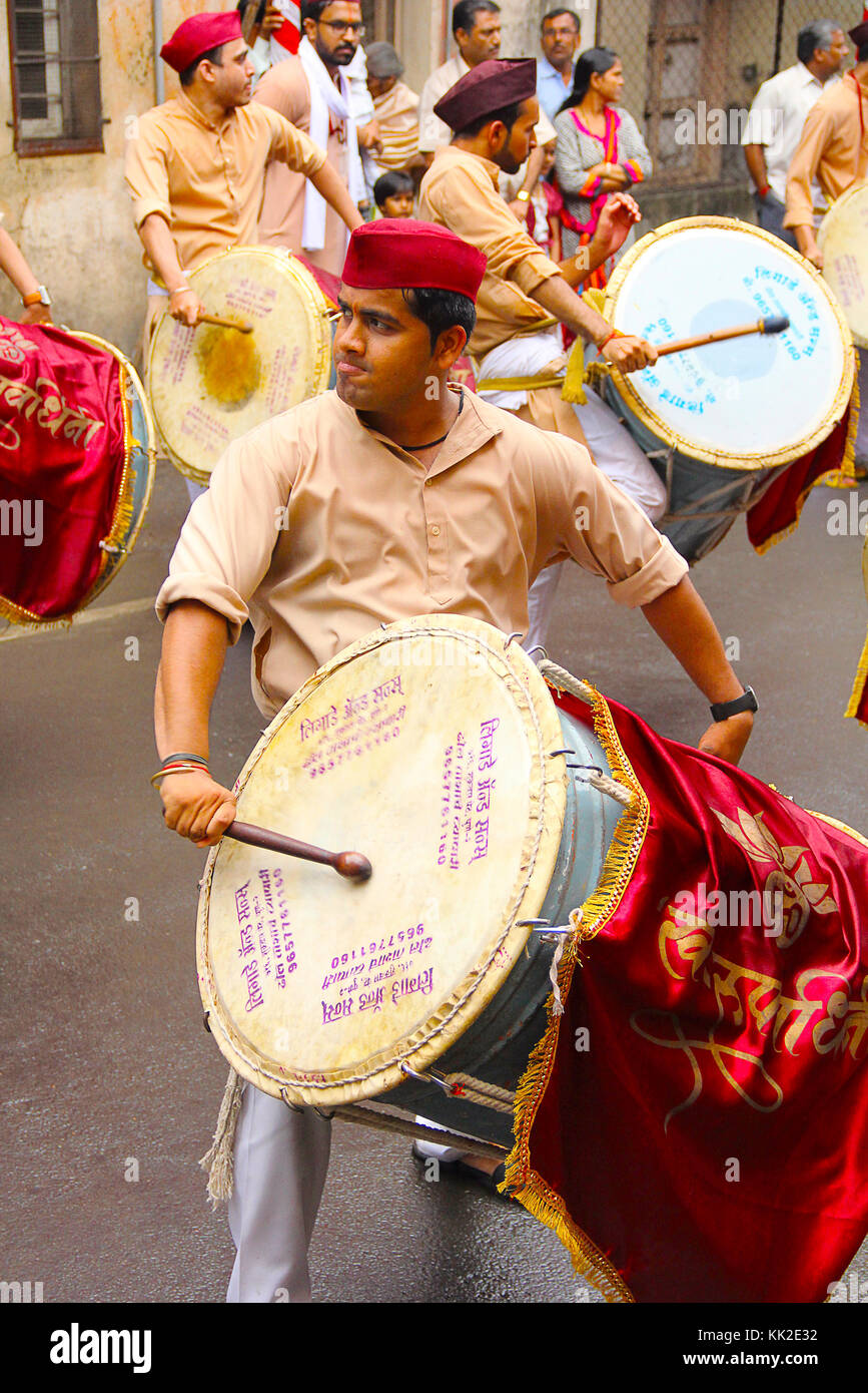 Young Indian man, dressed traditionally playing dhol-taasha during Ganapti Visarjan, Pune Stock Photo