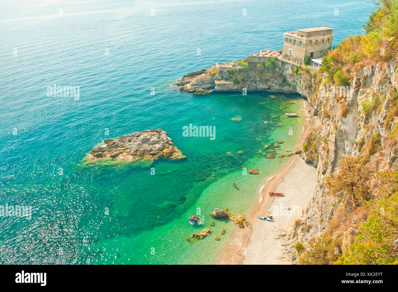 view of Cauco beach and Cerniola castle with people relaxing from hill top on sunny summer day in small village of Erchie, Amalfi, Italy Stock Photo