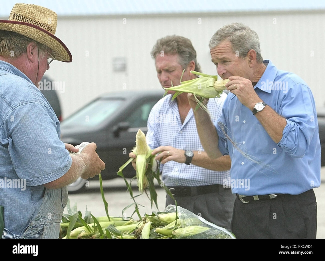 November 24, 2017 - Bettendorf, Iowa, U.S. - President Bush and country music star Larry Gatlin sample sweet corn at Ken Thomsen's stand at a farmers market in Bettendorf, Ia, Wednesday August 4, 2004.  The President had just left a campaign stop in Davenport, Ia. (Credit Image: © Greg Boll/Quad-City Times via ZUMA Wire) Stock Photo