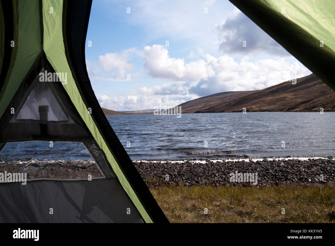 A view of a remote highland loch from a tent pitched near the water. Stock Photo