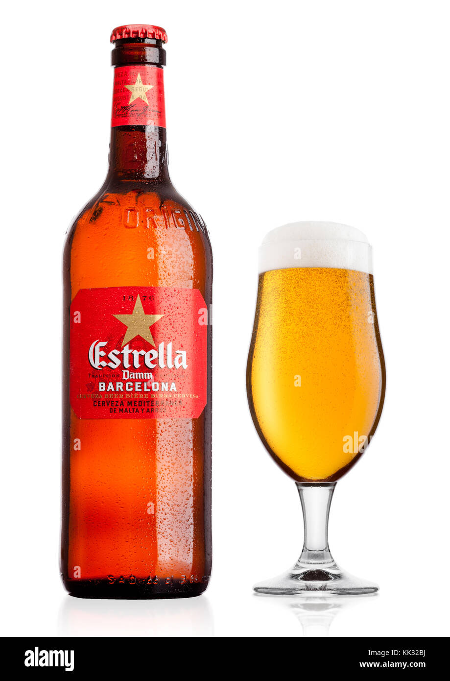 LONDON, UK - November 24, 2017: Bottle and glass of Estrella Damm beer on white background with reflection, Estrella Damm is a pilsner beer, brewed in Stock Photo