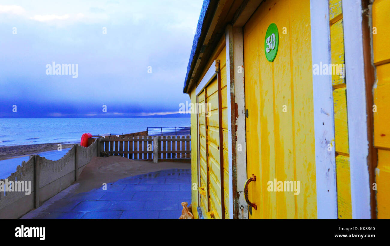 Yellow beach hut on a cold winters day at dusk on Fleetwood sea front with rain coming in on the distant horizon Stock Photo