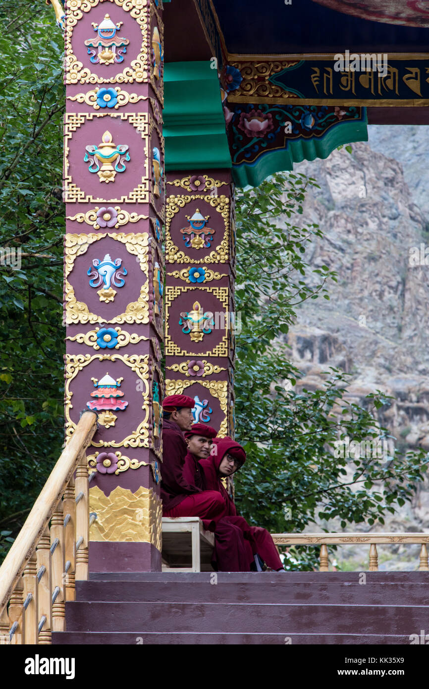 Three monks sit at the entry of HEMIS MONASTERY - LEH VALLEY, LADAKH Stock Photo