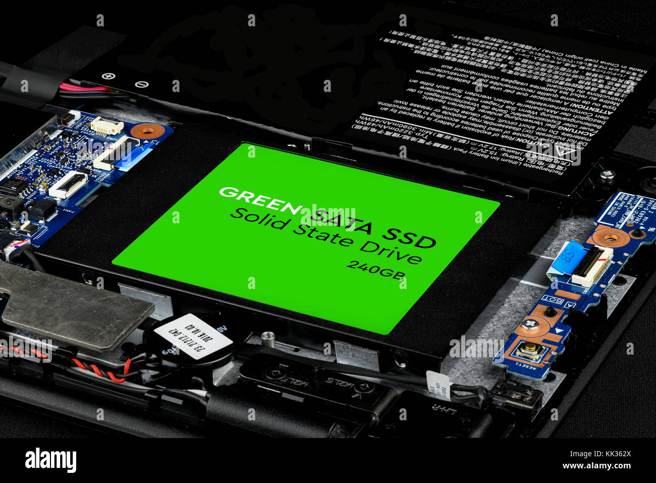 Green SATA SSD drive of a laptop, internal hard drive component Stock Photo