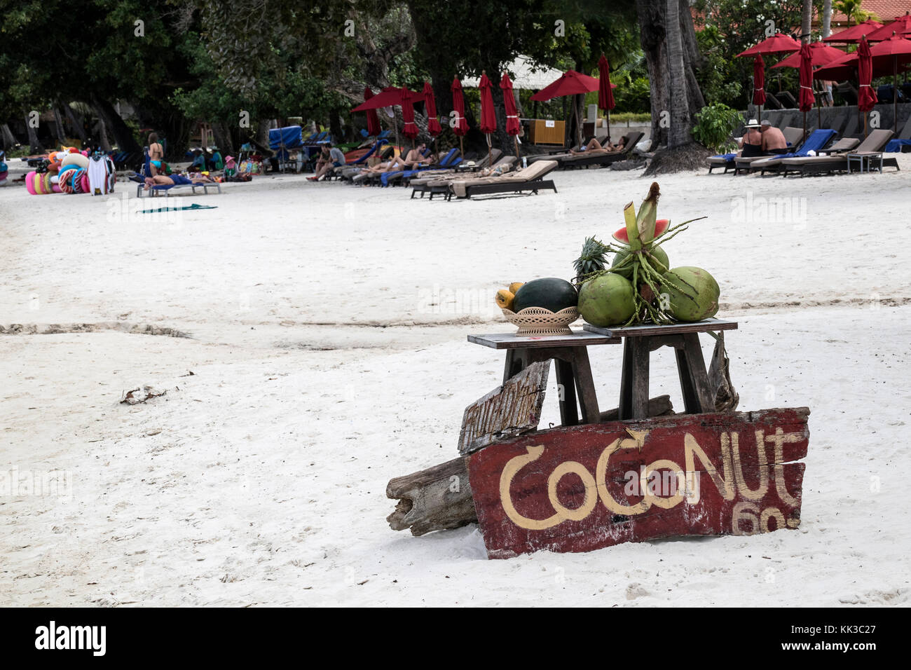 Coconuts for sale on Chaweng Beach on Koh Samui, Thailand with tourists