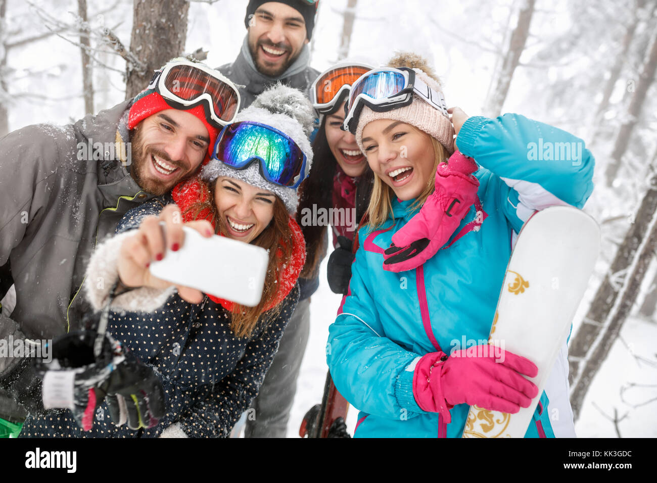 Smiling male with female skiers with ski equipment Stock Photo