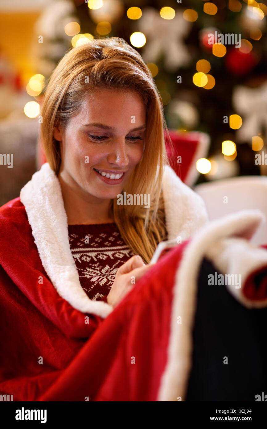 beautiful smiling woman texting messages on Christmas holiday Stock Photo