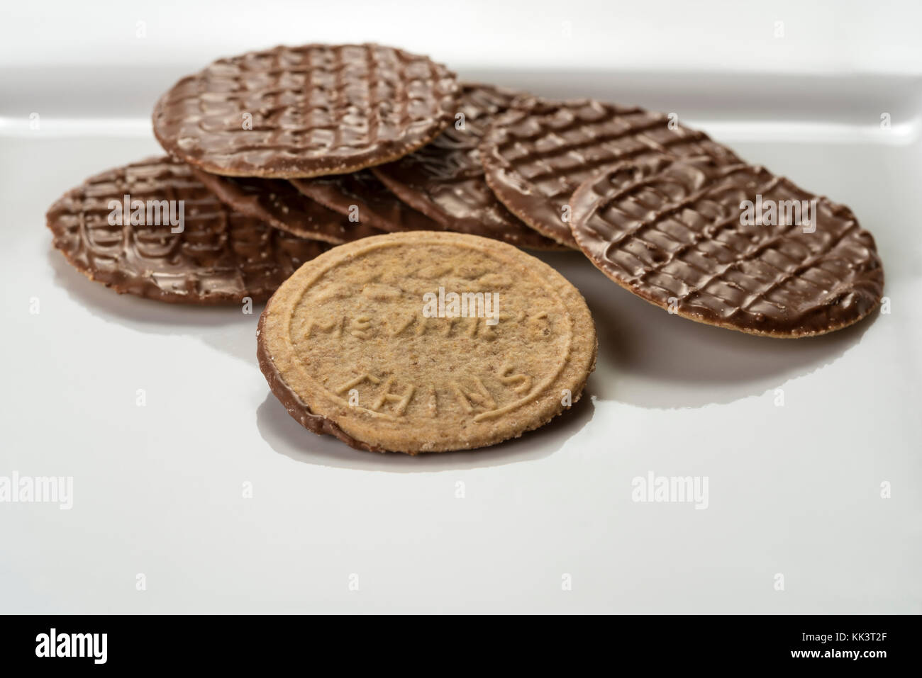 McVities Thins on a white square plate, chocolate biscuits. Stock Photo