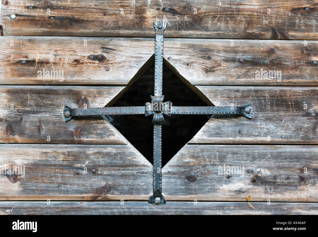 Old wooden water mill window closed with metal cross closeup in Western Carinthia, Austria Stock Photo