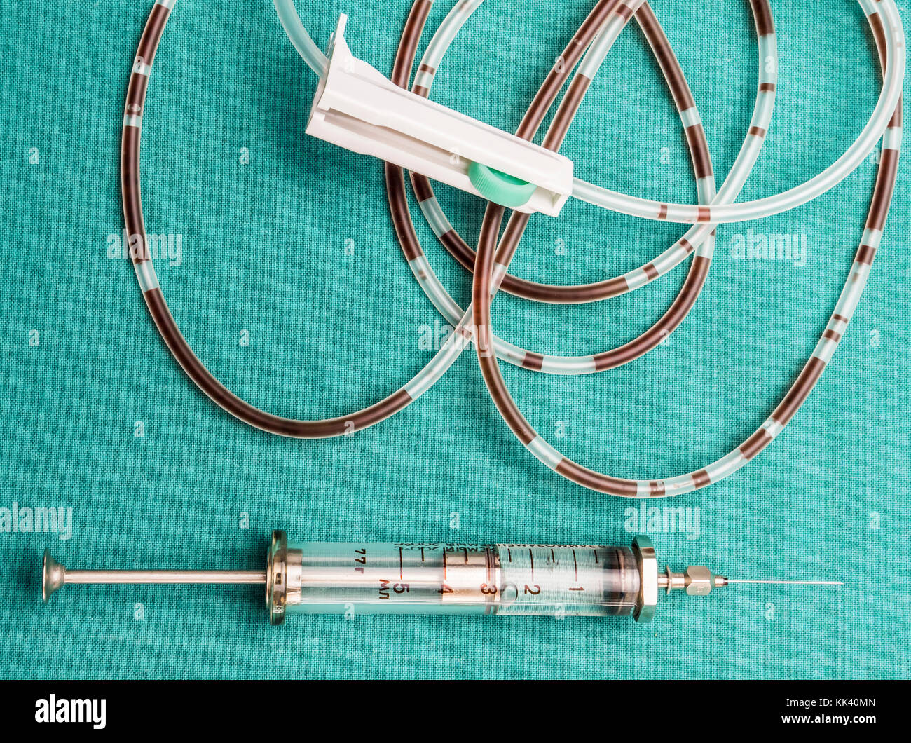 Drip irrigation system with traces of blood and vintage syringe, conceptual image Stock Photo