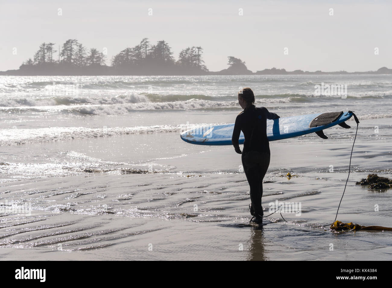 Chesterman beach near Tofino, BC, Canada (September 2017) - Woman holding a surfing board. Stock Photo