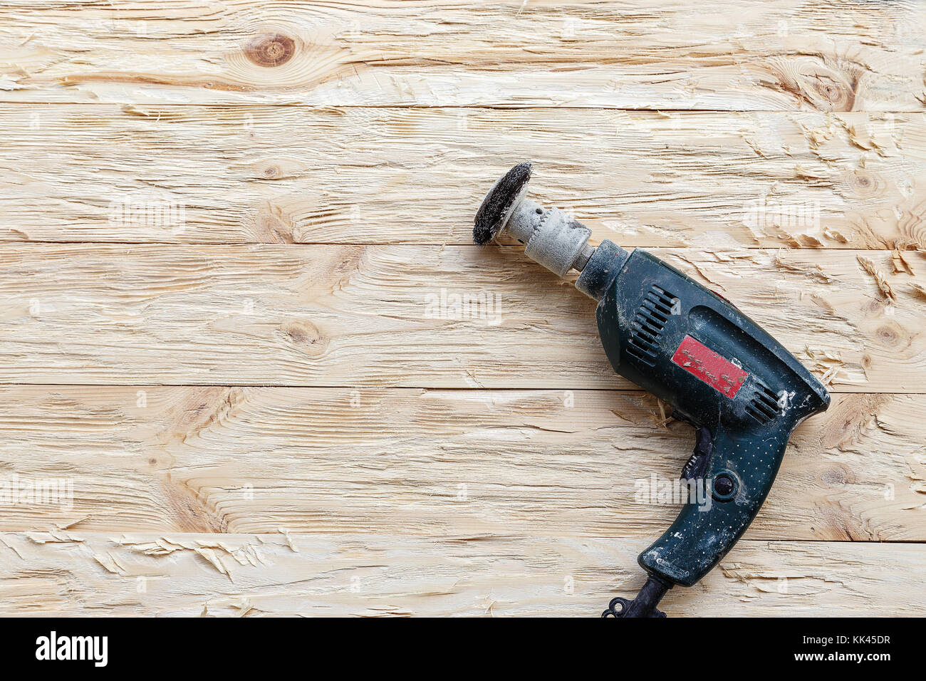 attachment on a drill, scrape, metal rotating brush. attachment is on a