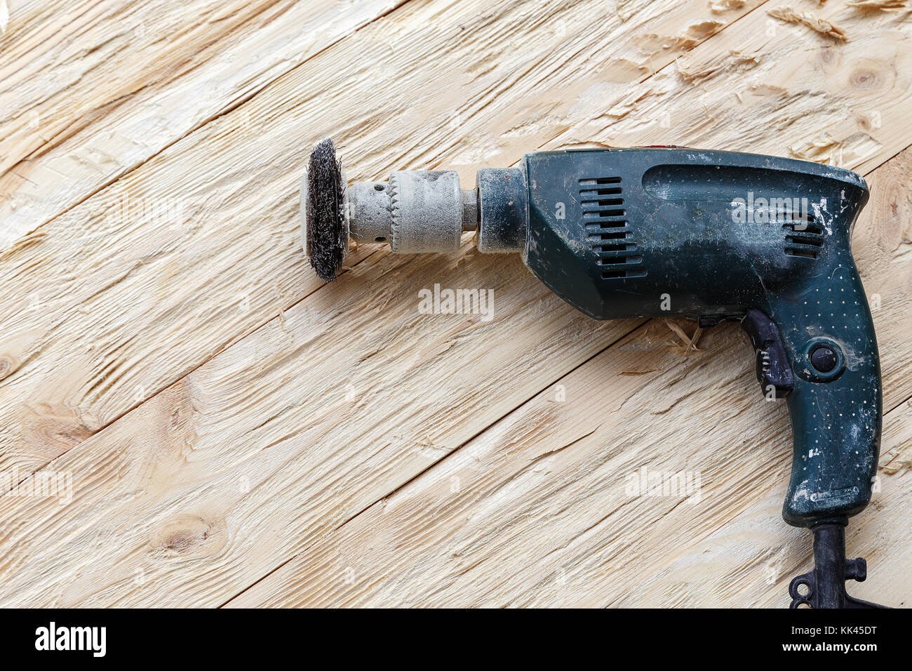 attachment on a drill, scrape, metal rotating brush. attachment is on a