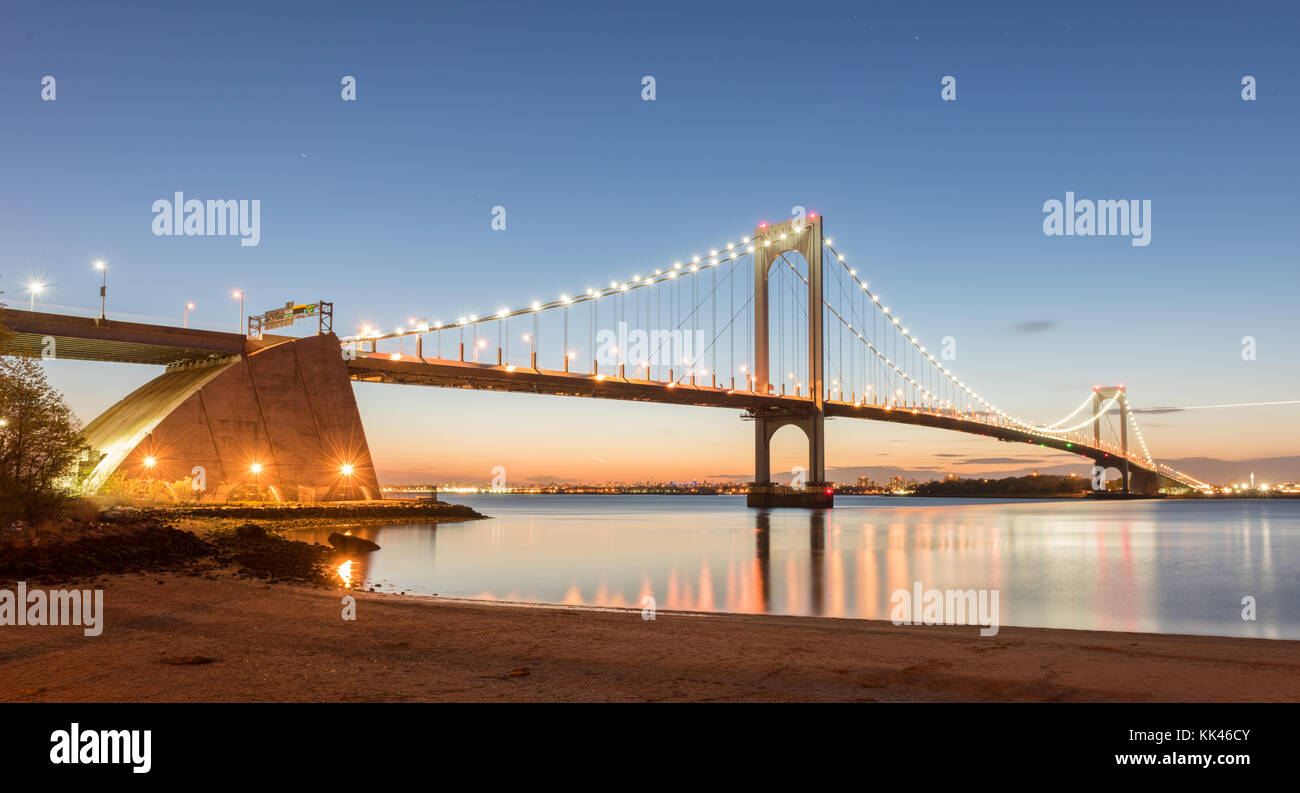 The BronxWhitestone Bridge reflecting on the East River at night in
