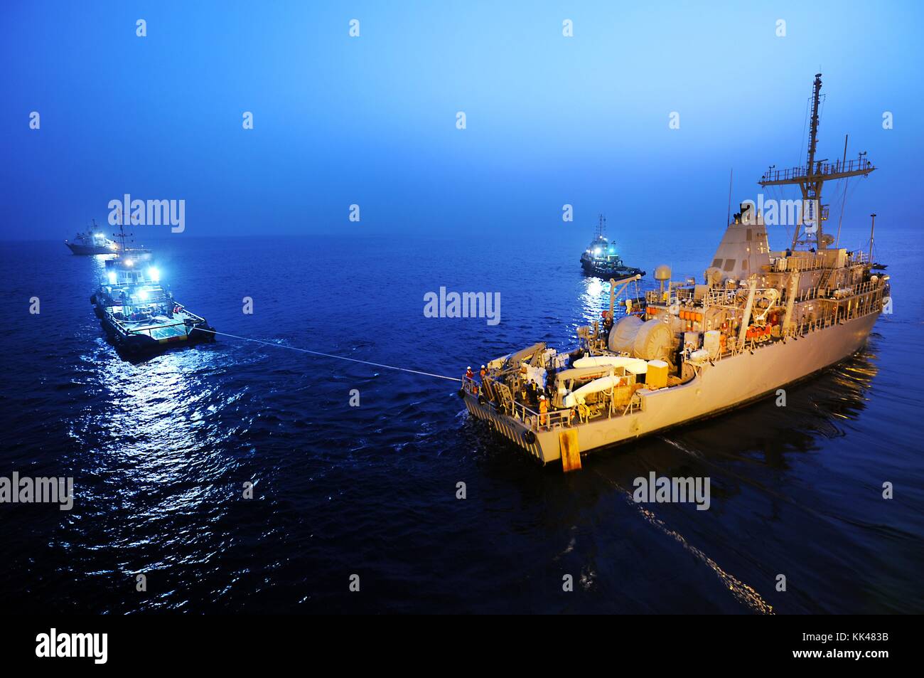 Tugboats pull the mine counter measure ship USS Devastator MCM 6 into