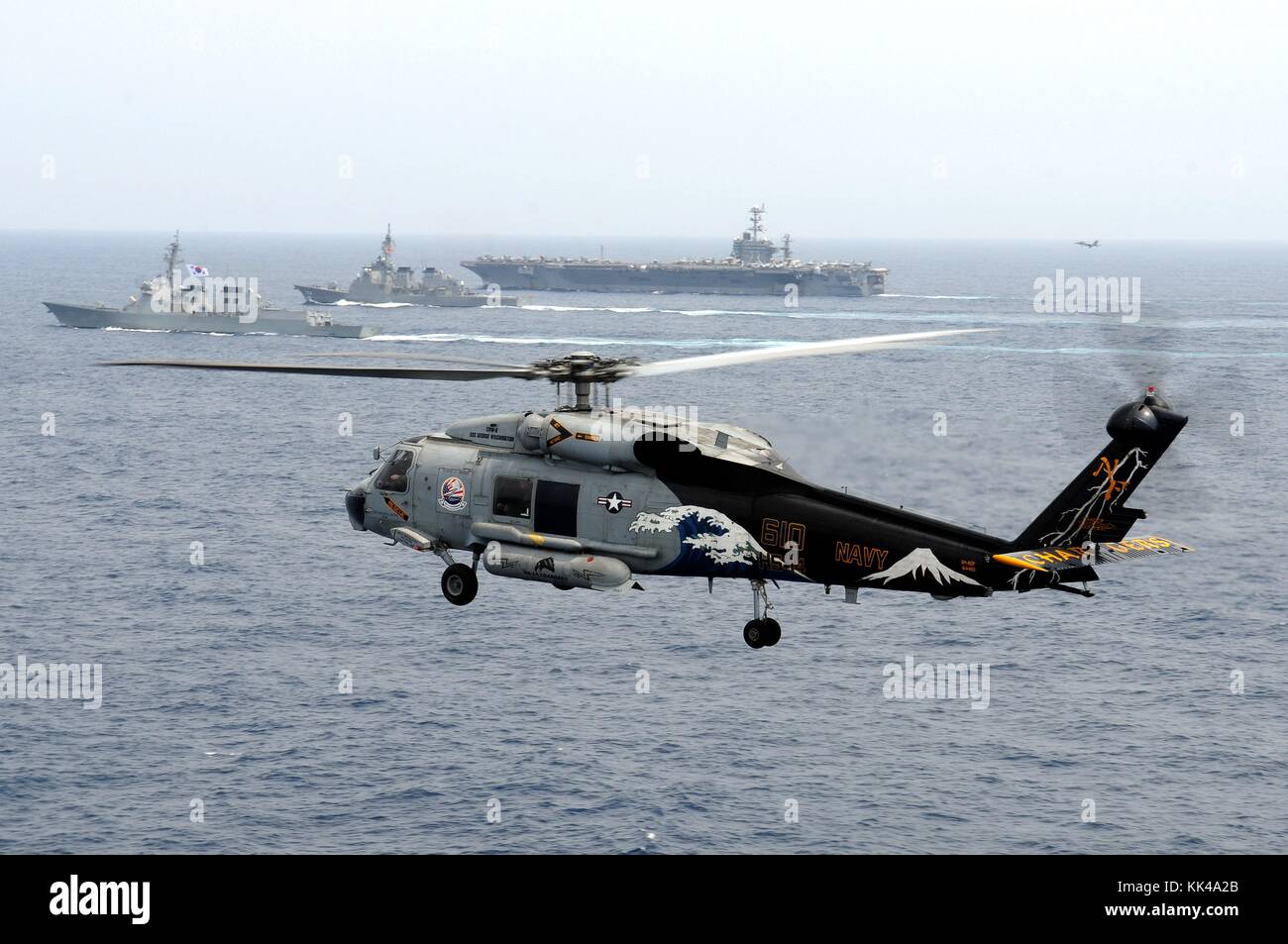 An SH-60F Seahawk helicopter, assigned to the Chargers of Helicopter Anti-Submarine Squadron HS 14, is airborne while the aircraft carrier USS George Washington CVN 73, the Japan Maritime Self-Defense Force destroyer JS Kirishima DD 174, and the Republic of Korea navy destroyer ROKS Sejong the Great DDG 991 participate a trilateral event, East China Sea, 2012. Image courtesy Mass Communication Specialist 1st Class Jennifer A. Villalovos/US Navy. Stock Photo