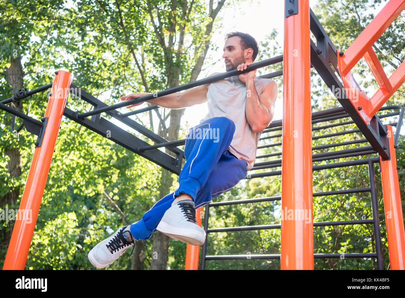 Strong young man doing amazing pull-up variation during extreme  Stock Photo