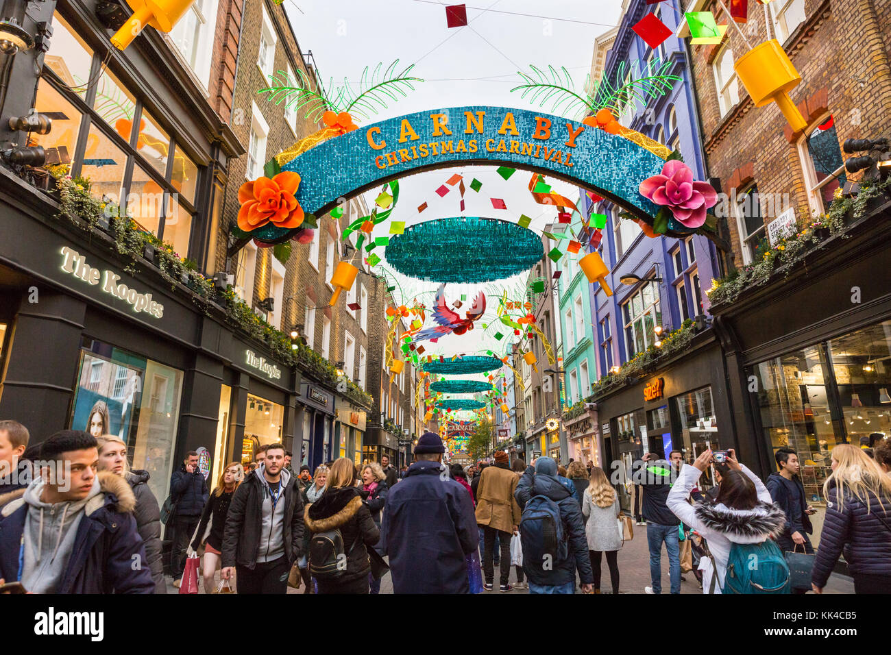 People walking in Carnaby Street, under the Christmas Carnival themed christmas lights, London Stock Photo