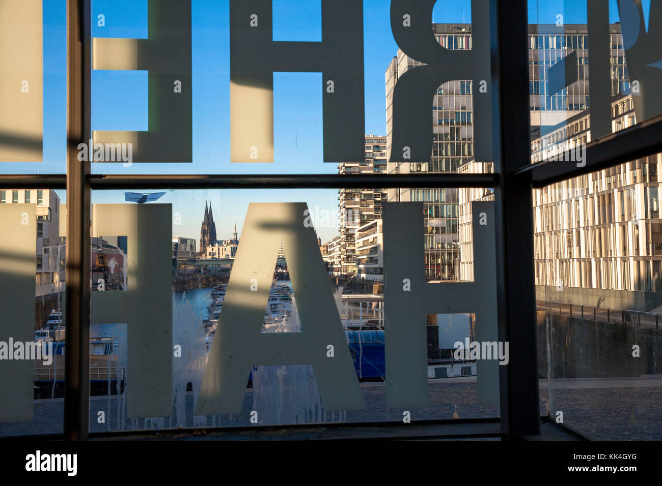 Germany, Cologne, the Rheinau harbour, view through the windows of a staircase with the inscription 'Rheinauhafen', in the background the cathedral.   Stock Photo