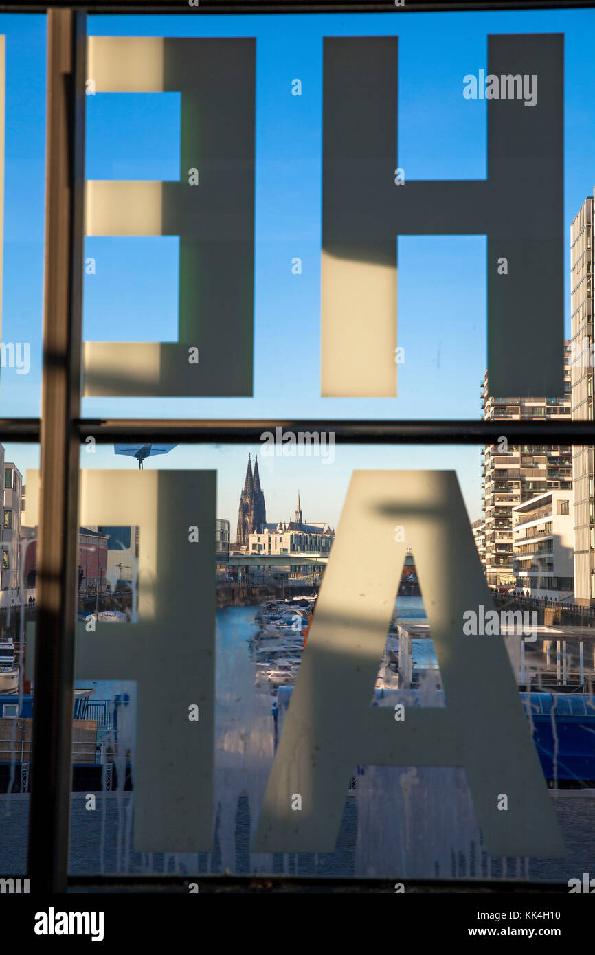 Germany, Cologne, the Rheinau harbour, view through the windows of a staircase with the inscription 'Rheinauhafen', in the background the cathedral.   Stock Photo