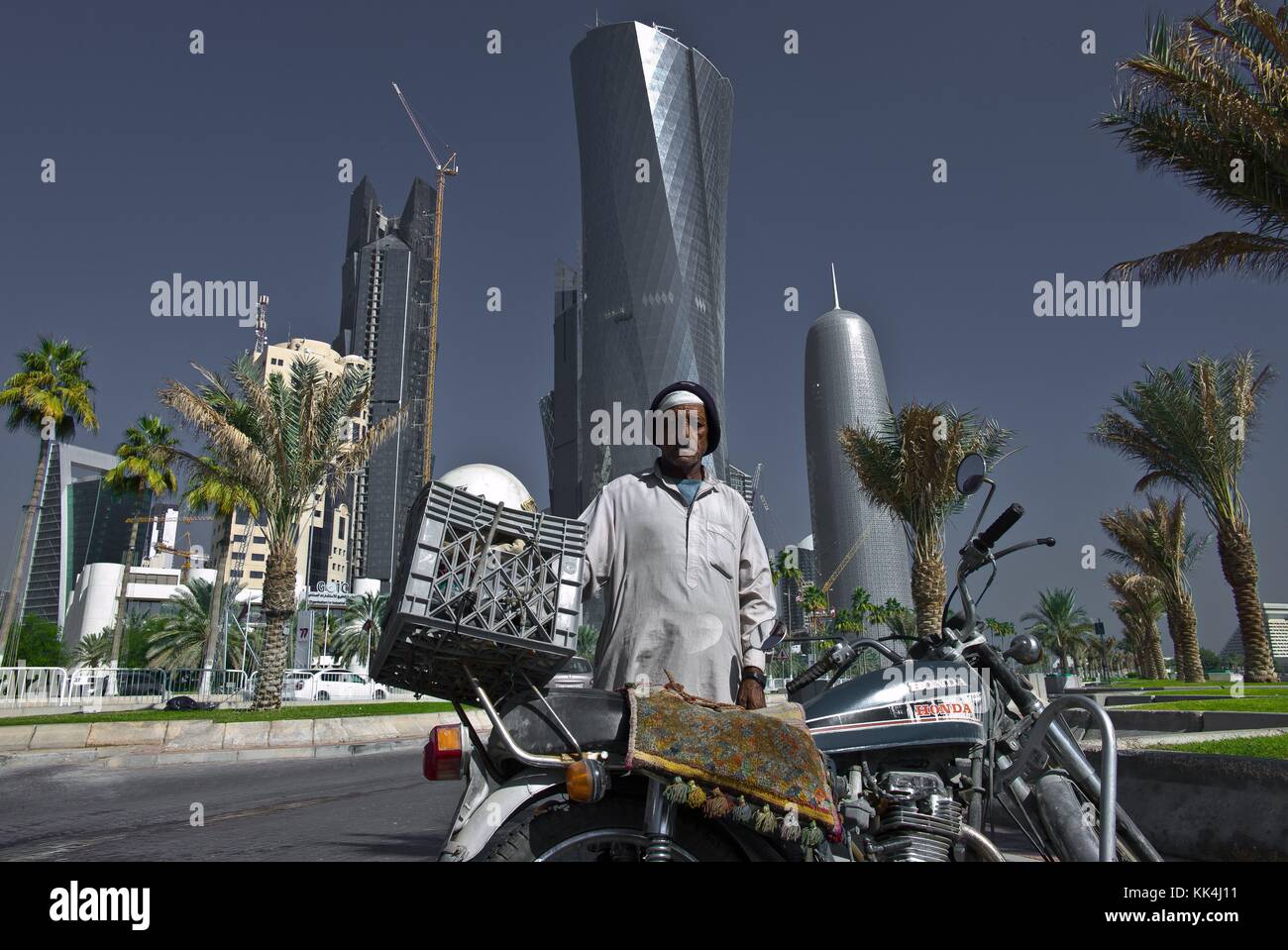 Doha, Qatar. -  07/12/2010  -  Qatar / Doha / Doha  -  A Pakistani and its motorcycle on the cornice of the city.   -  Sylvain Leser / Le Pictorium Stock Photo