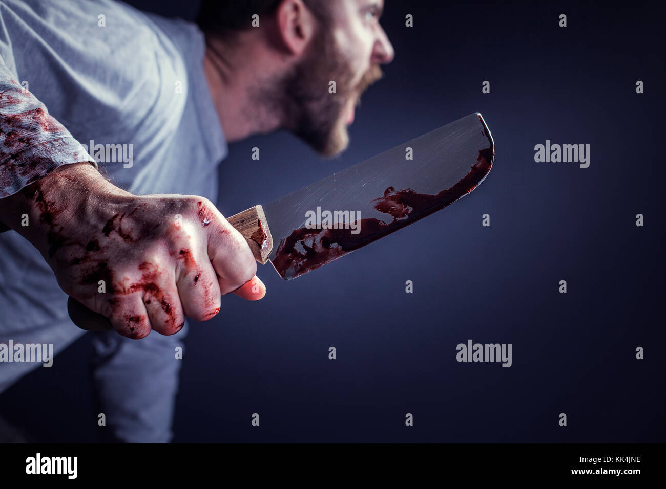 detail of man holding bloody knife crime concept Stock Photo