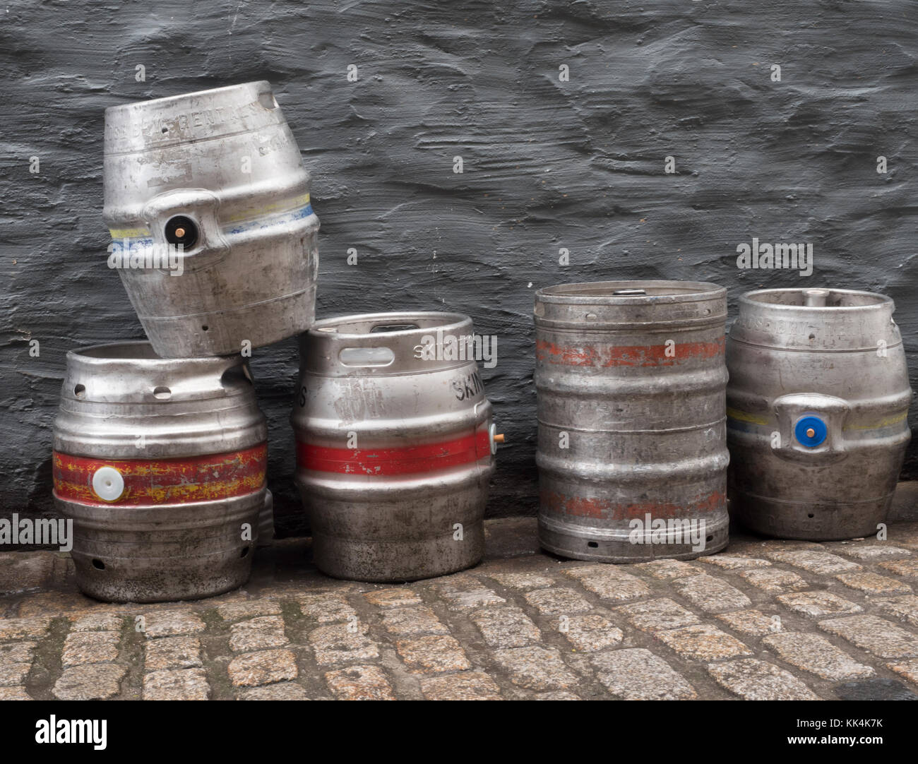 Discarded modern beer barrels (kegs) on a public street with cobble stones. Stock Photo