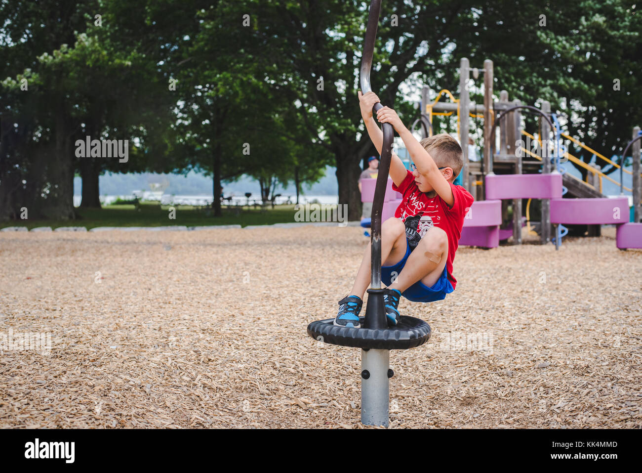 A boy child plays on playground equipment on a summer day Stock Photo
