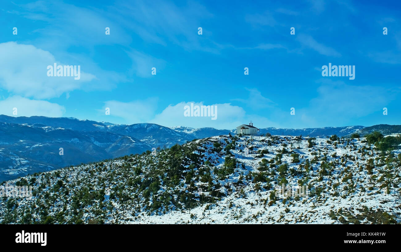 The picturesque winter landscape of Pindus mountains with the church on the top of the hill, Greece. Stock Photo