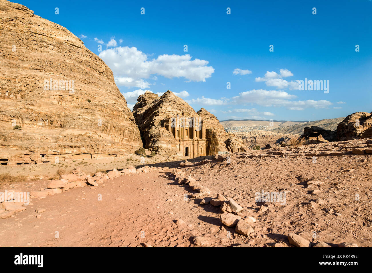 Landscape with side view of the Monastery (Ad Deir or El Deir) the monumental building carved out of rock in the ancient Nabataean city of Petra Stock Photo